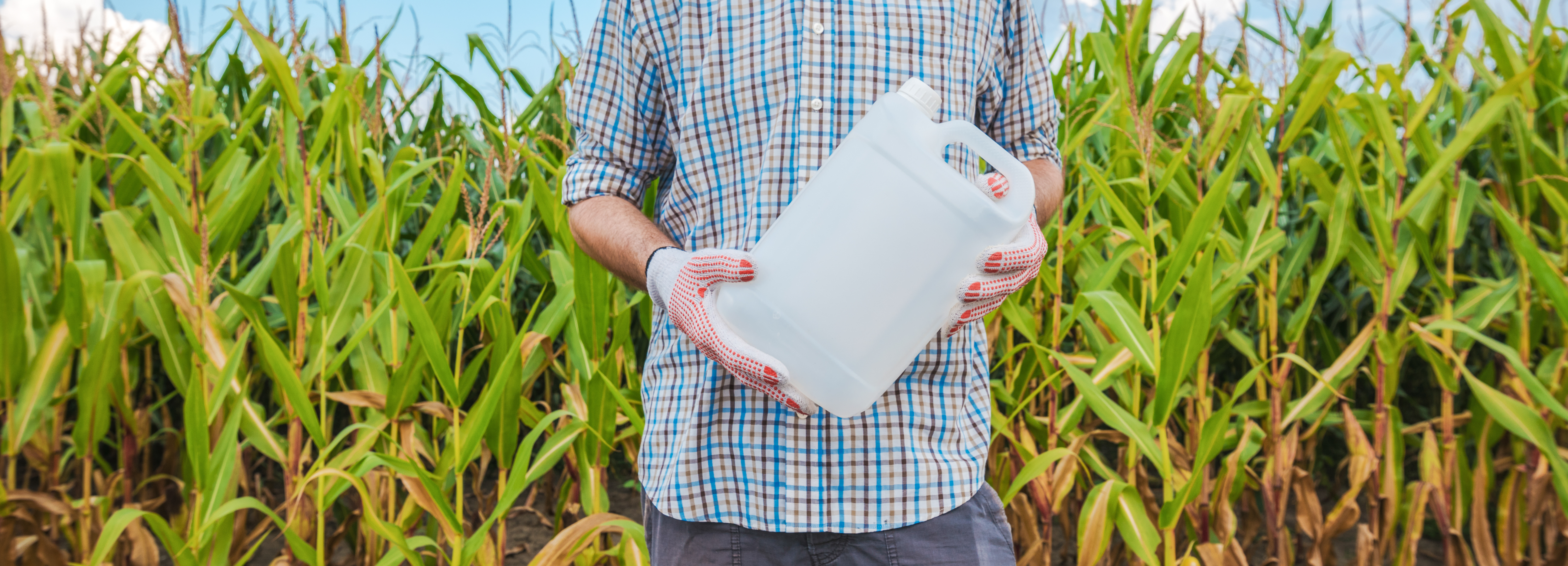 Farmer holding unlabeled pesticide jug in field