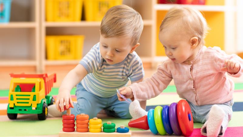 Preschool boy and girl playing on floor with educational toys. Children toddlers at home or daycare.